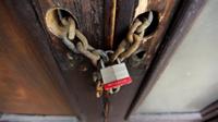 AP - FILE - In this March 6, 2009 file photo, a chain and padlock take the place of door ...