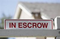 AP - In this photo made Tuesday, Nov. 17, 2009, an 'in escrow' sign has been added to a 'for ...