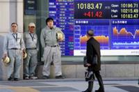 AP - A man checks the electronic stock board of a securities firm indicating Japan's Nikkei 225 stock average gained ...
