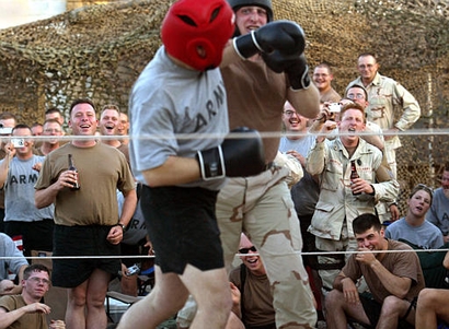 In this file photo, American troops cheer as fellow soldiers box during 'Fight Night' at the Abu Ghraib prison on the outskirts of Baghdad, Iraq, June 18, 2004. Soldiers volunteer to fight in the weekly Friday evening event, as comrades watch, many drinking ice cold non-alcoholic beer. (AP Photo/John Moore)