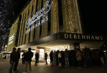 Shoppers wait outside Debenhams department store on Oxford street in London, early Friday, Dec. 26, 2008. Hundreds of shoppers queued outside stores Friday waiting to snap up a bargain in the seasonal sales. (AP Photo/Akira Suemori)