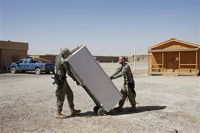 In this photo taken Monday, Oct. 5, 2009, US soldiers haul a refrigerator as they prepare to leave their base in Samarra, Iraq, 95 kilometers (60 miles) north of Baghdad. The base hand over comes as the US military works with Iraq to develop a security plan for a revered Shiite shrine that they hope will increase the city's economic viability. (AP Photo/Khalid Mohammed)