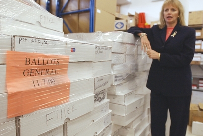 Theresa A. LePore, Supervisor of Elections Palm Beach County, stands by the stack of 2000 presidential ballots in her West Palm Beach, Fla., office, Thursday, May 1, 2003. LePore thinks the ballots are taking up storage space. Florida's hanging, dimpled and pregnant chads wreaked havoc in the 2000 presidential election. Now, the 6 million ballots are causing another problem: Should they be destroyed or saved because of their historical significance? (AP Photo/J.Pat Carter)