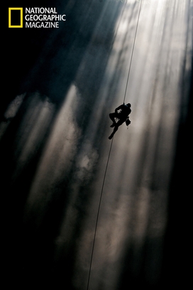A climber ascends a shaft of light in Loong Con, ...