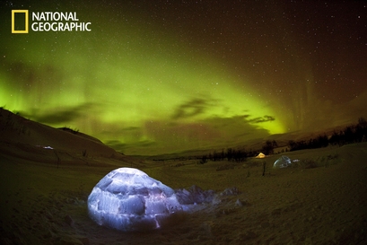 This shot captures igloos and the Northern Lights. ...