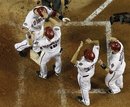 Arizona Diamondbacks ' Paul Goldschmidt , top left, is congratulated by teammates Willie Bloomquist (18), Josh Collmenter , and Miguel Montero , bottom right, after his grand slam against the Milwaukee Brewers during the fifth inning in Game 3 of baseball's National League division series Tuesday, Oct. 4, 2011, in Phoenix. The Diamondbacks defeated the Brewers 8-1.