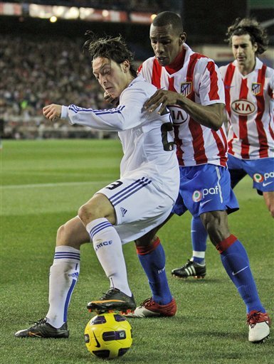 Real Madrid's Mesut Ozil From Germany, Left, Protects The Ball Against Atletico De Madrid's Luis Perea From Colombia,