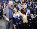 Former President Bill Clinton, left, poses with a Georgetown cheerleader for a photo after an NCAA college basketball game between Georgetown and Syracuse , Saturday, Feb. 26, 2011, in Washington. Syracuse won 58-51.