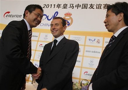 Real Madrid's former football striker Emilio Butragueno, center, shakes hand with Guangzhou Evergrande Football Club president Liu Yongzhuo, left, while Guangzhou Sports Bureau deputy director Kong Maosheng, right, look on during a Real Madrid China Tour press conference held in Guangzhou in south China's Guangdong province Thursday, May 26, 2011. Spanish League soccer team Real Madrid announced they will play two pre-season friendly matches against Tianjin Teda team and Guangzhou Evergrande team in China in August 2011. (AP Photo) CHINA OUT