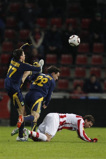 Metalist Players Sergei Pshenychnykh, Left, And Milan Obradovic, Center, Collide As They Try And Kick A High Ball,