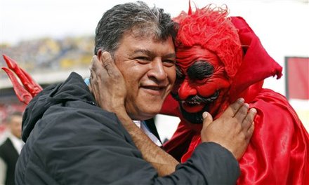 Claudio Borghi, Coach Of Argentina's Boca Juniors, Left, Is Greeted By An Independiente Team's Fan Wearing A Devil
