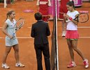 Ana Ivanovic of Serbia, right, and Slovakian player Dominika Cibulkova , left, listens to referee Maria Cicak of Croatia, center, ahead of their Fed Cup World Group play-off tennis match played in Bratislava, Sunday, April 17, 2011. Ivanovic retired from the match later due to injury.