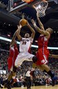 Toronto Raptors ' Leandro Barbosa , center, shoots between Los Angeles Clippers ' Eric Bledsoe , left, and Randy Foye during the second half of an NBA basketball game in Toronto, Sunday, Feb. 13, 2011.