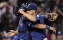 Texas Rangers starting pitcher Derek Holland , right, celebrates with catcher Yorvit Torrealba after the team beat the Seattle Mariners  in a baseball game Thursday, July 14, 2011, in Seattle. The Rangers won 5-0.