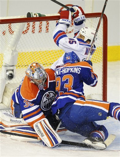 Edmonton Oilers' Ryan Nugent-Hopkins (93) And New York Rangers' Kris Newbury Crash Into The Net As Goalie Nikolai
