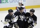 Pittsburgh Penguins ' Brooks Orpik , front center, celebrates with Sidney Crosby (87) and Chris Kunitz (14) after scoring a first-period goal, as New York Islanders ' PA Parenteau , rear, skates back to his bench during an NHL hockey game against in Pittsburgh on Monday, Nov. 21, 2011.The Penguins won 5-0.