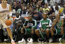 Charlotte Bobcats forward Eduardo Najera (21) looks to score as Boston Celtics forward Kevin Garnett , second from left, guard Rajon Rondo , center,  guard Ray Allen , second from right, and forward Paul Pierce (34) sit on the  bench in the fourth quarter of an NBA basketball game in Charlotte, N.C., Saturday, Dec. 11, 2010. The Celtics won 93-62.