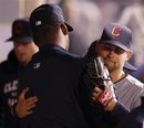 Cleveland Indians starting pitcher Mitch Talbot , right, hugs a teammate after leaving the field against the Los Angeles Angels during the ninth inning of a baseball game in Anaheim, Calif., Monday, April 11, 2011.
