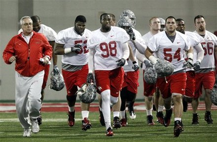 FILE - In this March 31, 2011 file photo, Ohio State defensive coach Jim Haycock, left, runs with a group of defensive players during the first day of NCAA college football practice in Columbus, Ohio. Even though most of the starters from a year ago have graduated, one of the biggest surprises at Ohio State this spring is the effectiveness of the Buckeyes defense.