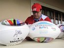 In this image provided by Global Football, CONADEIP All-Stars head coach Juan Carlos Maya autographs footballs for the Kilimanjaro Bowl college football game, Thursday, May 19, 2011 in Arusha, Tanzania. The game, featuring Drake University against an all-star squad from a collection of private universities in Mexico, is scheduled to be played on Saturday, May 21.