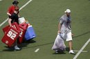 Jordan Palmer , right, carries a bag of NFL footballs as Cincinnati Bengals ' Andy Dalton , second from left, carries equipment with University of Cincinnati operation employee Skippy Buken, Wednesday, June 8, 2011, during a football player-organized workout at Nippert Stadium on the Cincinnati campus, in Cincinnati. (AP Photo/The Cincinnati Enquirer, Michael E. Keating) NO SALES; MANDATORY CREDIT