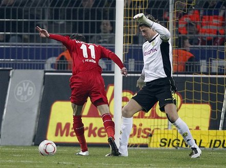 Cologne's Milivoje Novakovic Of Slovenia, Left, And Dortmund Goalkeeper Roman Weidenfeller Challenge For The Ball