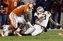 Virginia Tech quarterback Logan Thomas , right, is tackled by Clemson's Jonathan Willard , left, and Andre Branch , bottom, during the second half of the Atlantic Coast Conference championship NCAA college football game in Charlotte, N.C., Saturday, Dec. 3, 2011. Clemson won 38-10.