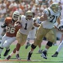 FILE - In this Sept. 13, 1997, file photo, UCLA tailback Keith Brown (1) follows the lead of offensive tackle Kris Farris (71) for a 29-yard run against Texas during an NCAA college football game in Austin, Texas. Texas defensive tackle Chris Akins is at left. UCLA won 66-3. On Saturday, The Bruins come back to Austin this weekend. The current Longhorns were hardly in grade school in 1997, but fans and former players will always remember the day UCLA jammed a big ol' stick right into the eyes of Texas.