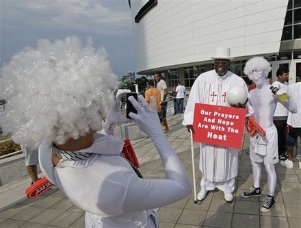 The Rev. Abraham J. Thomas poses for a photo with fans outside American Airlines Arena before Game 6 of the NBA Finals basketball game between the Miami Heat and the Dallas Mavericks Sunday, June 12, 2011, in Miami.