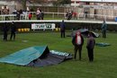 The remains of the two race horses that died lay covered in the parade ring at Newbury Racecourse Newbury England Saturday, Feb. 12, 2011. The two horses collapsed and died in the parade ring amid fears they were electrocuted. The reasons for the deaths of Fenix Two and Marching Song before Saturday's first race were not immediately announced by officials at the southern England course. (AP Photo/Steve Parsons/PA) UNITED KINGDOM OUT NO SALES NO ARCHIVE