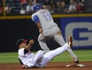 Texas Rangers ' Nelson Cruz continues to third base while stealing second  as Atlanta Braves shortstop Alex Gonzalez lets the throw from catcher Brian McCann pass during the sixth inning of a baseball game, Saturday, June 18, 2011, in Atlanta.