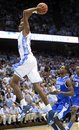 North Carolina 's John Henson drives to the basket as Kentucky's Brandon Knight (12) looks on during the first half of an NCAA college basketball game in Chapel Hill, N.C., Saturday, Dec. 4, 2010.