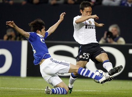 Schalke's Atsuto Uchida Of Japan, Left, And Milan's Yugo Nagamoto Challenge For The Ball