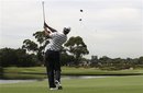U.S. golfer Tiger Woods plays a shot across a water hazard on the 14th during a pro-am event of the Australian Open golf tournament in Sydney, Australia, Wednesday, Nov. 9, 2011.