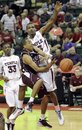 Texas A&M 's B.J. Homes, center, loses control of the ball as he goes in for a basket against Temple's Ramone Moore and Scootie Randall (33) during the first half of an NCAA college basketball game at the Old Spice Classic tournament in Lake Buena Vista, Fla., Sunday, Nov. 28, 2010.