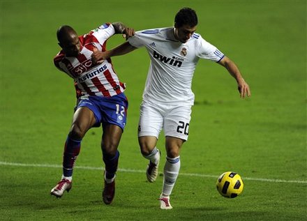 Real Madrid's Gonzalo Higuain From Argentina, Right, Vies For The Ball With Sporting De Gijon's Gregory Arnolin From