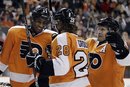 Philadelphia Flyers players, from left, Wayne Simmonds , Claude Giroux and Kimmo Timonen , of Finland, celebrate after Simmonds' goal in the second period of an NHL hockey game against the Tampa Bay Lightning , Saturday, Dec. 10, 2011, in Philadelphia. Philadelphia won 5-2.