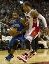 Orlando Magic guard Jameer Nelson , left, yells as he drives to the hoop past Toronto Raptors guard Jerryd Bayless during first-half NBA basketball game action in Toronto on Sunday, April 3, 2011.