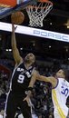 San Antonio Spurs ' Tony Parker , left, goes up for a shot past Golden State Warriors ' Stephen Curry during the first half of an NBA basketball game Tuesday, Nov. 30, 2010, in Oakland, Calif.