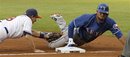 Texas Rangers ' Elvis Andrus , right, slides safely into third, beating the tag of Cleveland Indians third baseman Adam Everett , in the third inning of a baseball game in Cleveland on Friday, June 3, 2011.