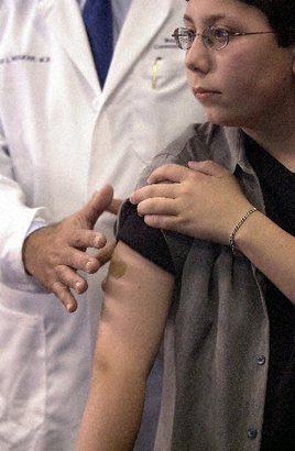 **FILE PHOTO** Surgeon David L. Wulkan left shows where he implanted a computer chip in the right arm of Derek Jacobs May 10 2002 in Boca Raton Fla. Jacobs who was 14 at the time as well as his parents became the first to be implanted with tiny computer chips that researchers hope will advance the way people carry medical information with them in case of emergencies. (AP Photo/ Steve Mitchell)