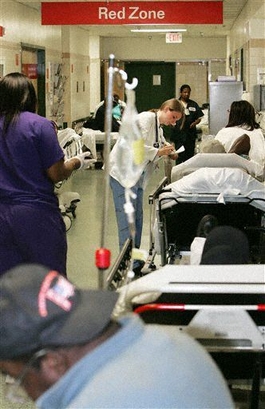 **FILE PHOTO** An emergency room physician center attends to a patient while gurneys patients and staff fill the hallway in the Red Zone trauma center at the Emergency Room of Grady Hospital in downtown Atlanta in this Nov. 2 2005 file photo. (AP Photo/Ric Feld Files)