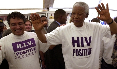 **FILE PHOTO** Former South African President Nelson Mandela, right, and AIDS activist Zackie Achmat, left wear 'HIV-positive' t-shirts on a visit to the Nolungile Clinic and Community Health Center in Khayelitsha,  Cape Town, South Africa, Dec. 12, 2002.   Mandela,  who led the fight against apartheid and remains South Africa's most revered public figure, has emerged as a champion of the fight against the country's rampant AIDS epidemic. (AP Photo)