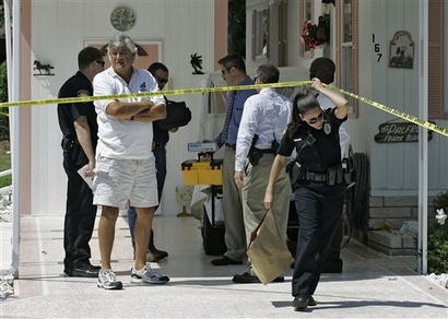In this file photo, Tarpon Spring, Fla., police officers remove evidence as they continue to investigate the scene where Deborah Palfrey, also known as the DC Madam, committed suicide May 1, 2008 at her parents mobile home. (AP Photo/Chris O'Meara)