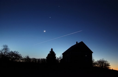 In a rare alignment, the crescent moon, and the planets Venus, center, and Jupiter shine above a farmhouse in the eastern pre-dawn sky, in this  Nov. 10, 2004 file photo, in Brunswick, Maine.  (AP Photo/Robert F. Bukaty)