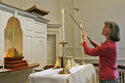 Phyllis Grose lights candles for a noon Eucharist service at The Falls Church in its historic chapel in this file photo from Nov. 29, 2006 in Falls Church, Va.  (AP Photo/Jacquelyn Martin)